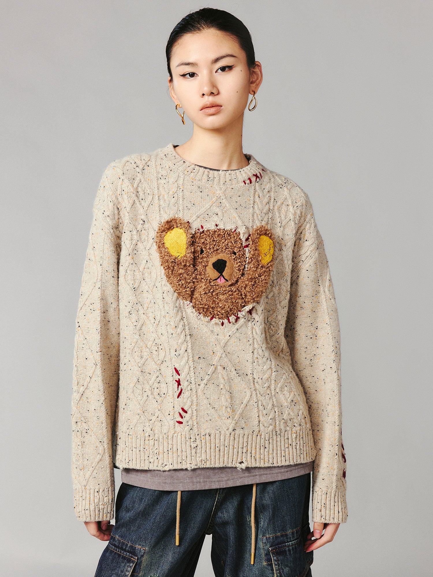 Teddy bear peeking through sweater