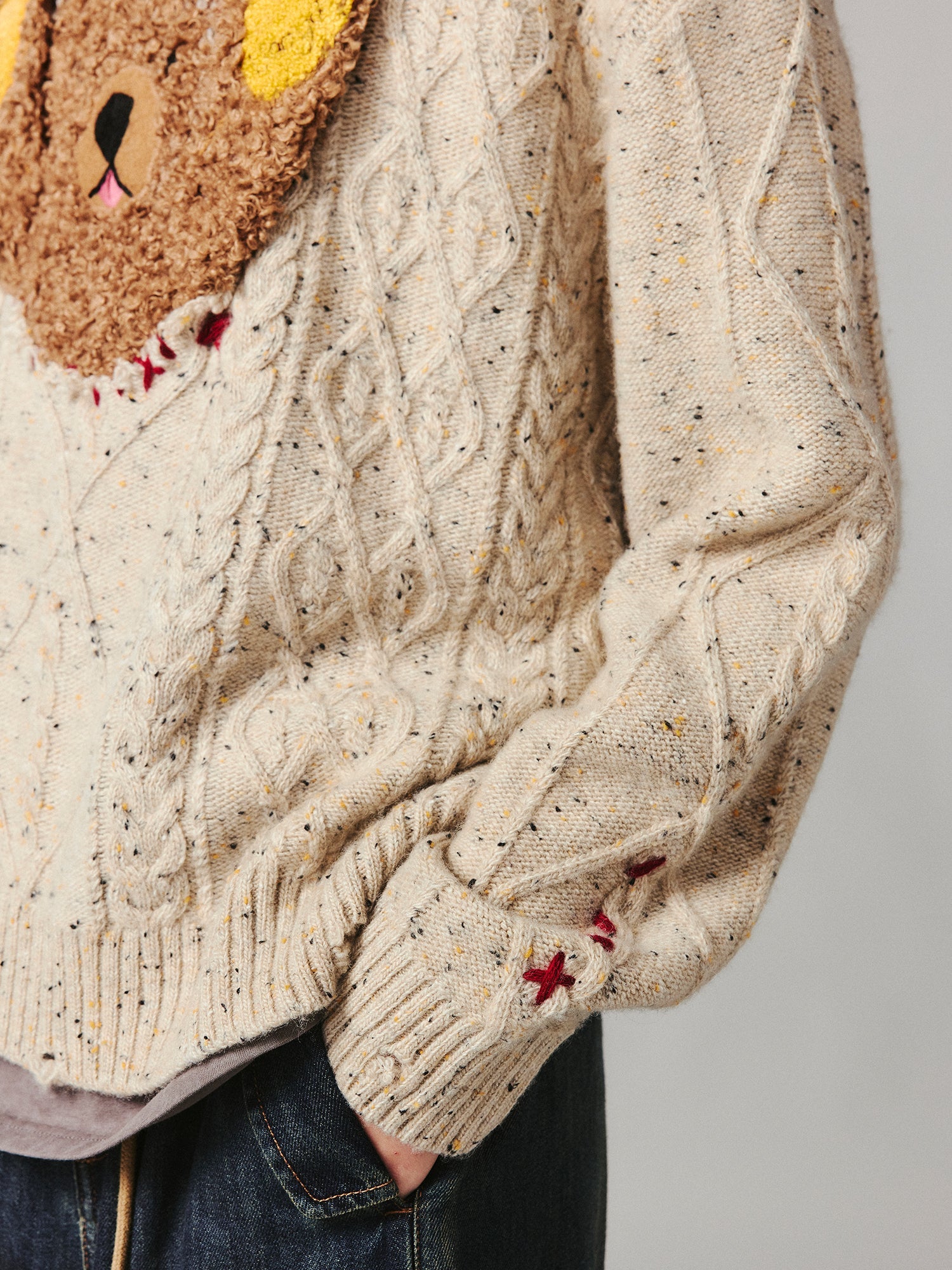 Teddy bear peeking through sweater