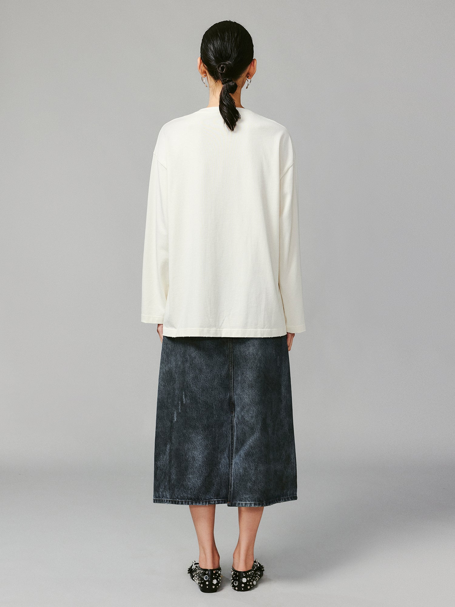 Teddy bear peeking through long-sleeve T-shirt