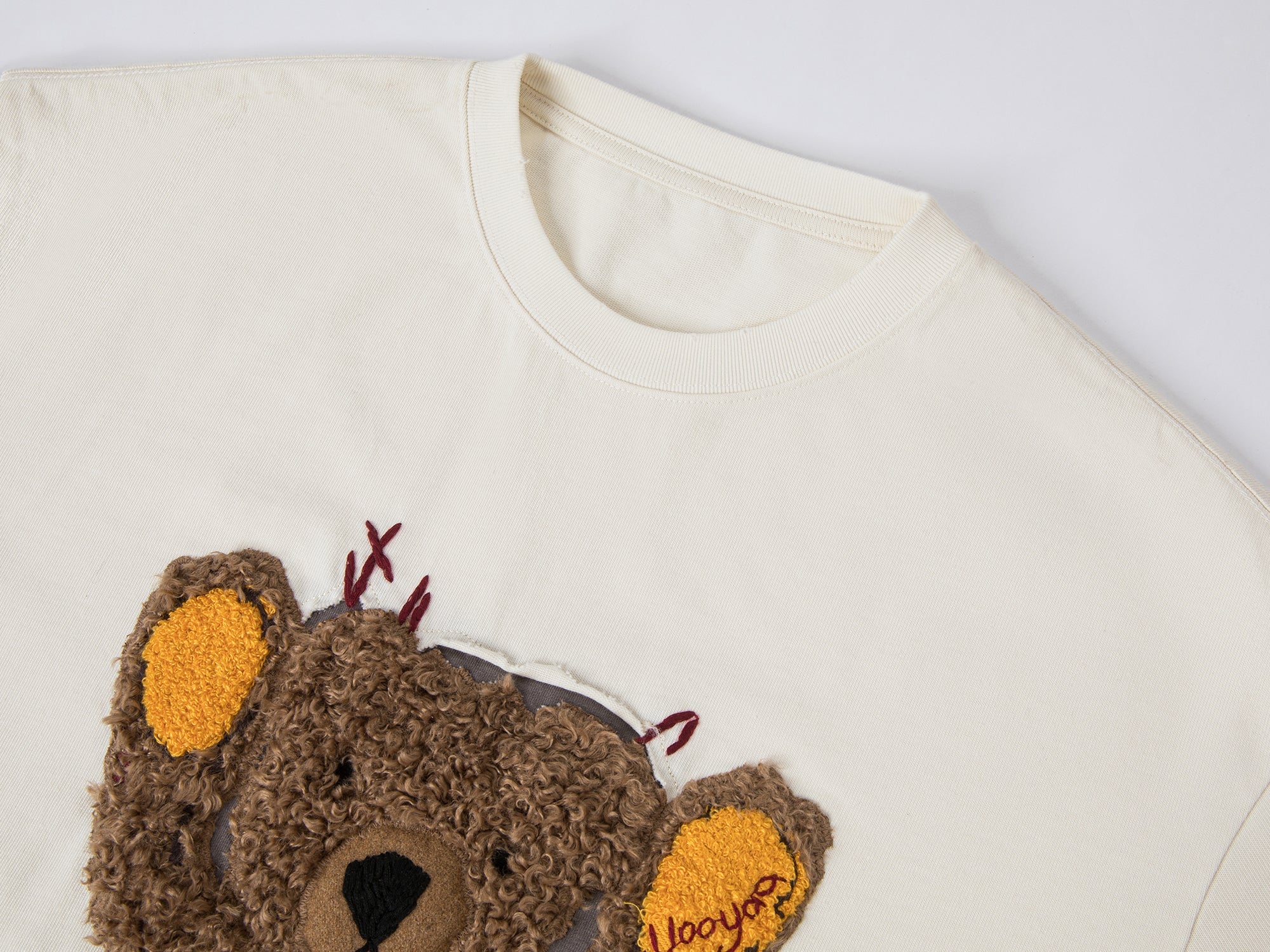 Teddy bear peeking through long-sleeve T-shirt