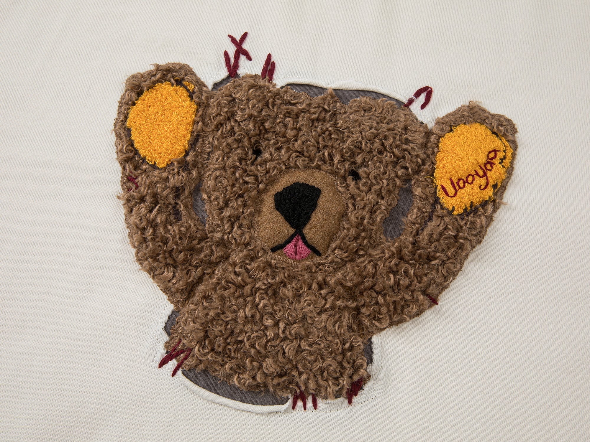 Teddy bear peeking through long-sleeve T-shirt