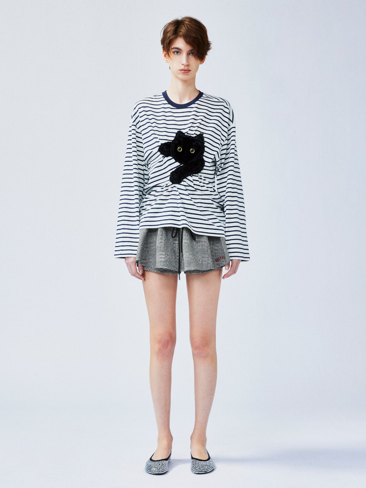 遊び心のある猫がベッドシーツを引っ掻くストライプTシャツ