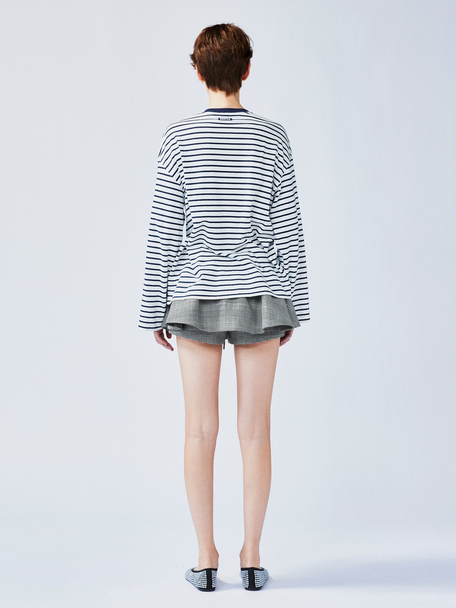 Playful cat scratching bedsheet striped T-shirt