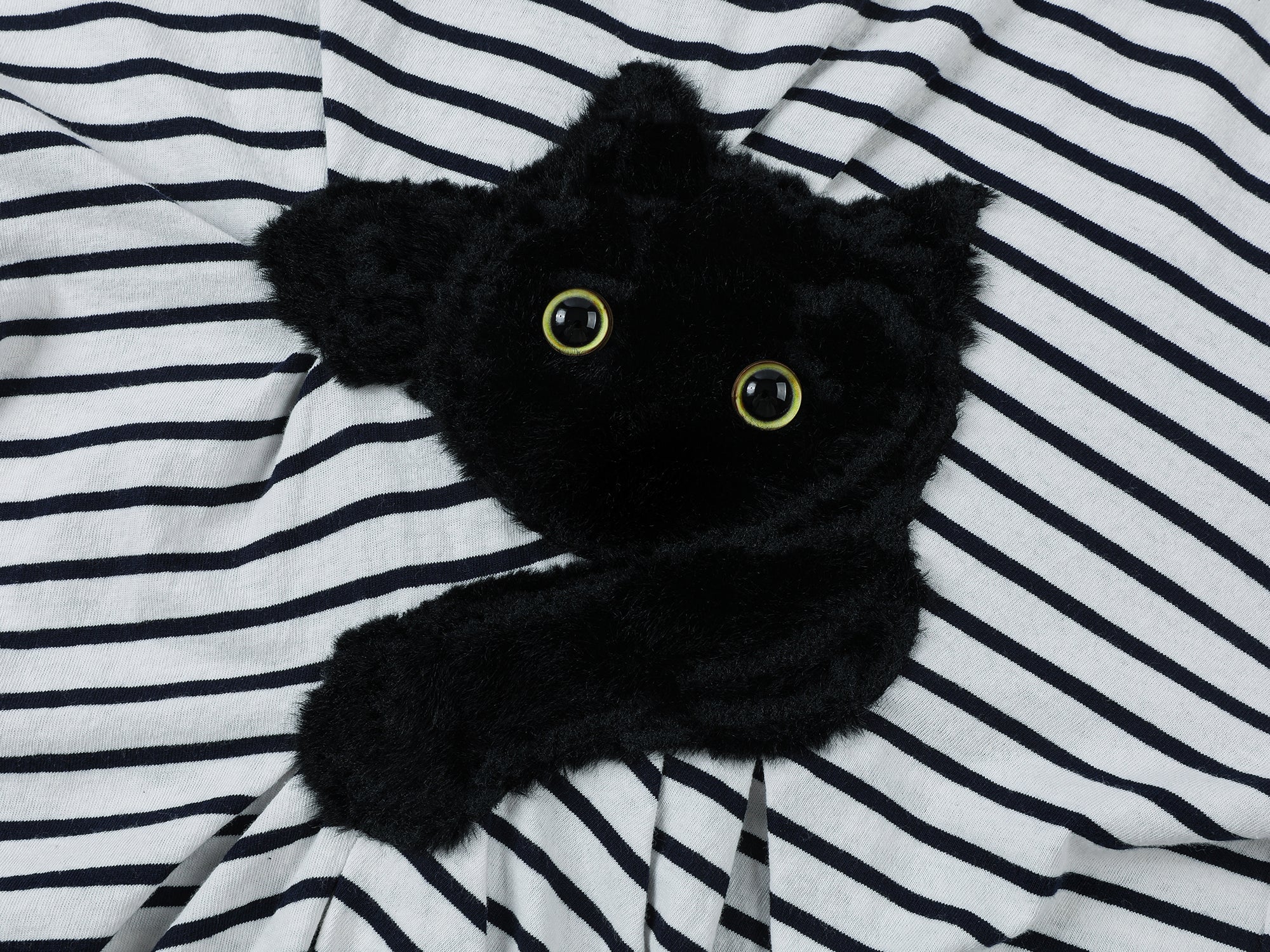 Playful cat scratching bedsheet striped T-shirt
