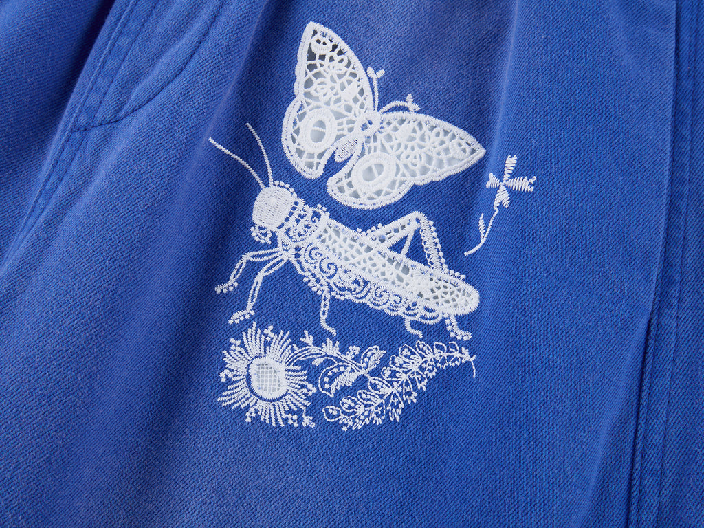 Lace insect and floral motif curved denim pants