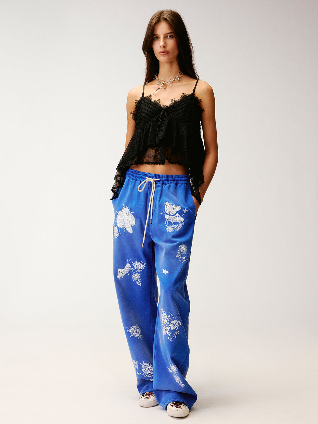 Lace insect and floral motif curved denim pants