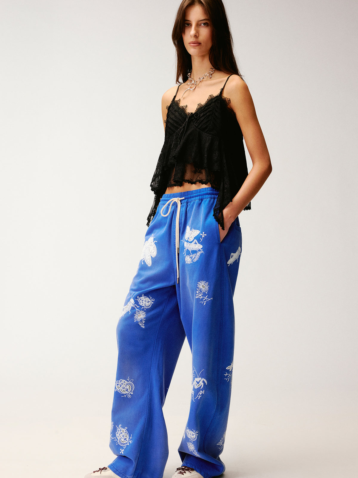 Lace insect and floral motif curved denim pants