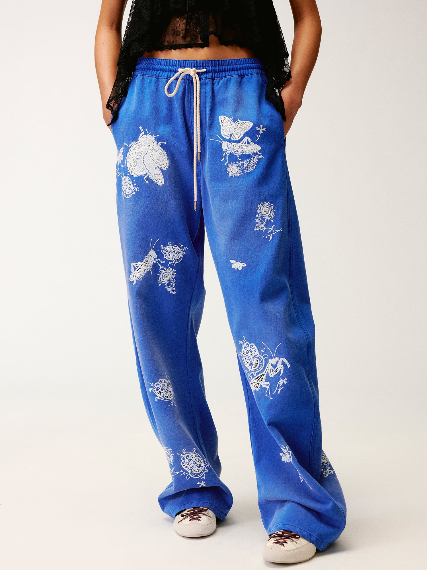 Lace insect and floral motif curved denim pants