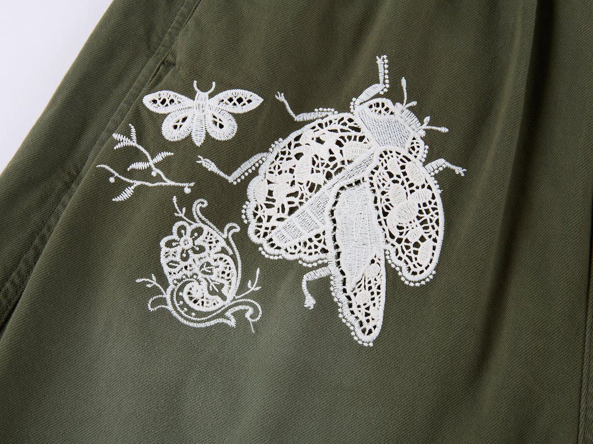 Lace insect and floral motif curved denim pants