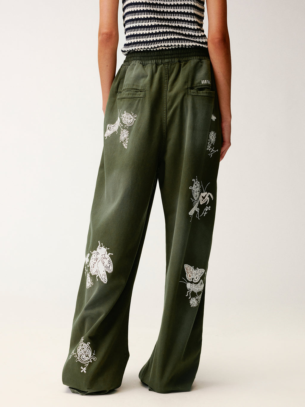 Lace insect and floral motif curved denim pants