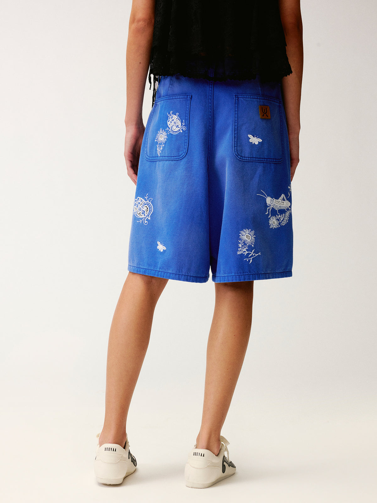 Lace insect and floral motif klein blue denim shorts